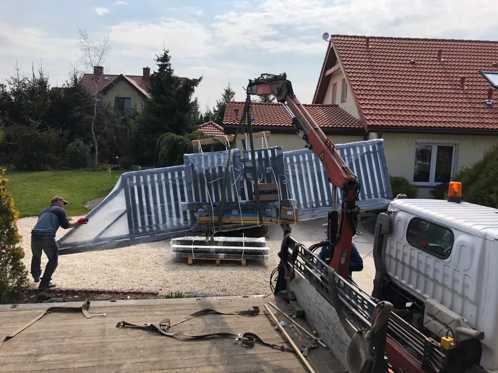 Montaż stalowego ogrodzenia przy użyciu samochodu z żurawiem